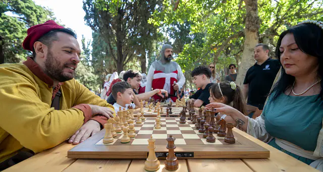 Παρτίδα σκάκι ανάμεσα σε δύο συμμετέχοντες με μεσαιωνικές φορεσιές.